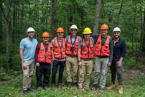 A team of W&由生物学教授Jason Kilgore博士带领的J学生.D. 在宾夕法尼亚州西北部的阿勒格尼国家森林工作，监测受翠绿灰螟(EAB)影响的白蜡树的健康状况。, 这是一种来自亚洲的入侵昆虫，已经杀死了美国和加拿大各地数亿棵白蜡树. 创意总监Matt Michalko和平面设计师Cameron Haid在花了2天时间记录他们的工作后与工作人员合影.