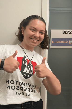 W&即将升入高年级的茱莉亚·赫维茨站在密歇根大学社会心理实验室外竖起了两个大拇指.